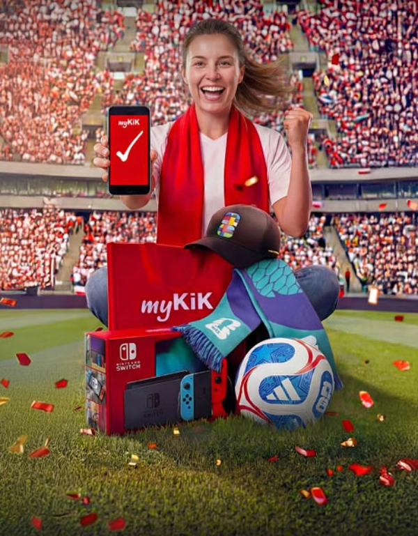 Osoba na stadionu drží chytrý telefon s aplikací myKiK, obklopena herní konzolí Nintendo Switch, fotbalovým míčem, čepicí, šálou a balíčkem myKiK.
