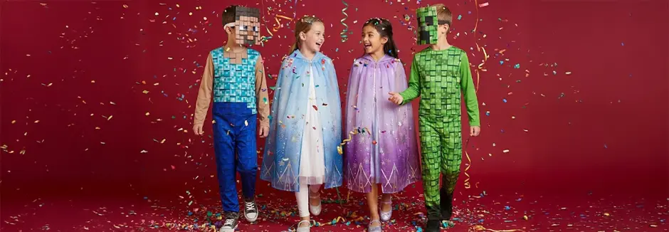 Vier Kinder in bunten Kostümen stehen zusammen, umgeben von Konfetti, vor einem lebhaften roten Hintergrund.