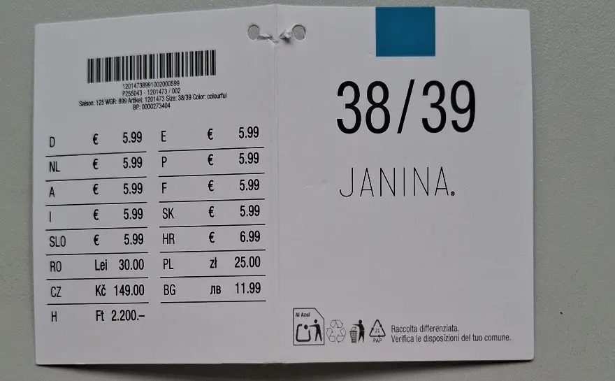 Štítek na oděvu s velikostí 38/39 pro „JANINA“ s cenovými údaji v různých měnách a kódy produktů. Štítek na oděvu s velikostí 38/39 pro „JANINA“ s cenovými údaji v různých měnách a kódy produktů.
