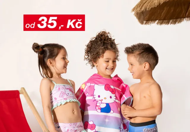 Tři děti v plavkách stojí vedle sebe, jedno z nich je zabalené do barevného ručníku Hello Kitty, v pozadí je plážové křeslo a slaměný slunečník.