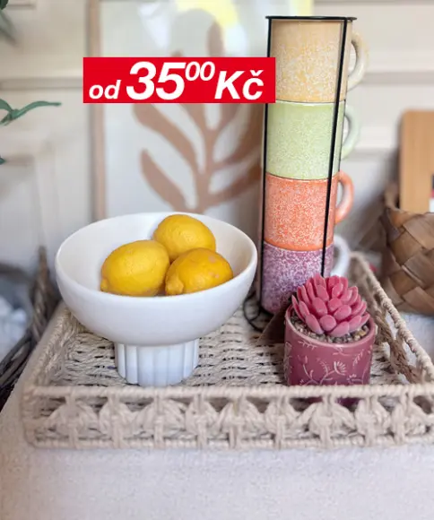 Minimalistický dekor s malým zrcadlem, zarámovaným listovým uměním a vázou se sušenými květinami na dřevěném podnosu, na pozadí neutrální stěny.
