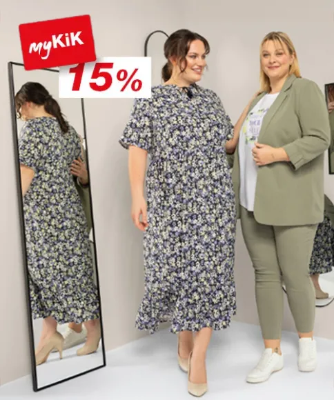 Dvě ženy stojí před zrcadlem a předvádějí stylové outfity, vedle cedule s 15% slevou od myKiK.