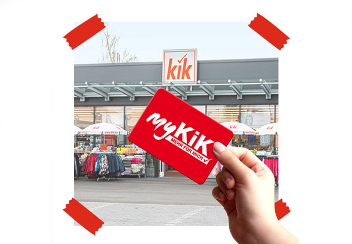 Karta myKiK je držena před prodejnou KiK směrem ke kameře.